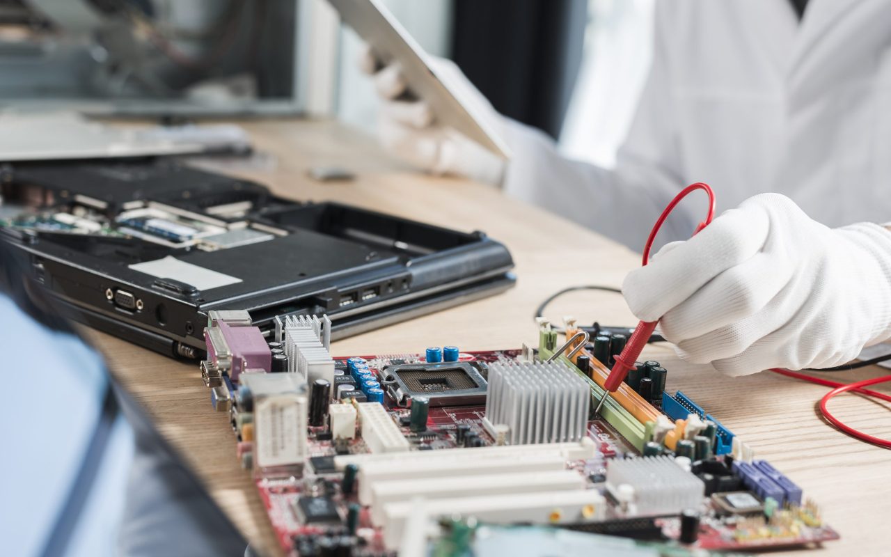male-technician-examining-mother-board-with-digital-multimeter